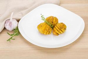 Baked tomato on the plate and wooden background photo