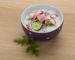 Okroshka in a bowl on wooden background photo