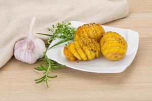 Baked potato on the plate and wooden background photo