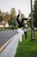 atractiva mujer flaca haciendo un backbend mientras muestra un salto mortal. foto