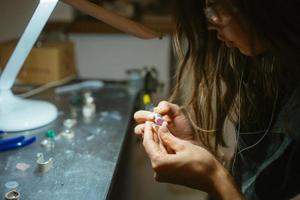 girl master processes the metal plate in the home workshop photo