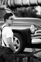 Guy in a shirt with suspenders posing at the retro car photo