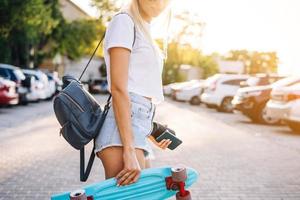 Young girl with a skateboard on a car park. photo