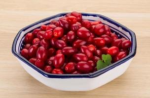 Cornus in a bowl on wooden background photo