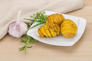 Baked potato on the plate and wooden background photo