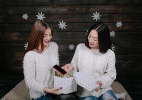 Two young girls holding holiday present photo