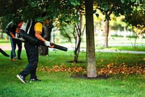 A woman operating a heavy duty leaf blower. photo