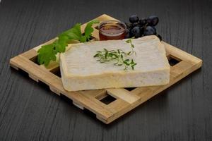 Brie cheese on wooden board and wooden background photo