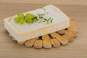 Brie cheese on wooden board and wooden background photo