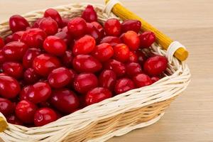 Cornus in a basket on wooden background photo