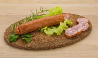 Sausage on wooden board and wooden background photo
