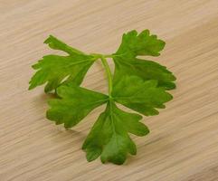 Celery leaves on wooden background photo