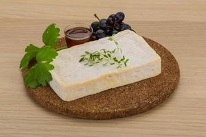 Brie cheese on wooden board and wooden background photo