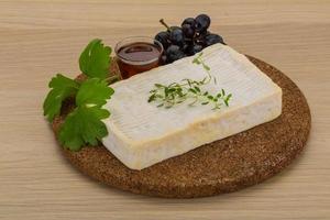 Brie cheese on wooden board and wooden background photo