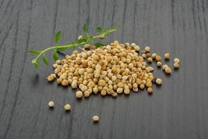 Coriander seeds on wooden background photo