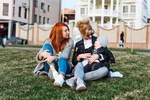 mamá y tía juegan con un niño en el parque foto