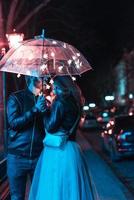 Guy and girl kissing under an umbrella photo