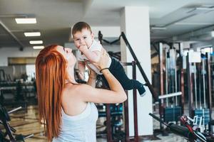 joven madre con su hijo pequeño en el gimnasio foto