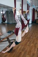 las chicas jóvenes hacen yoga aéreo en el gimnasio foto