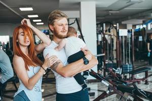 familia joven con niño pequeño en el gimnasio foto