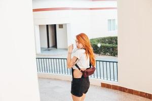 Woman with long red hair standing alongside photo