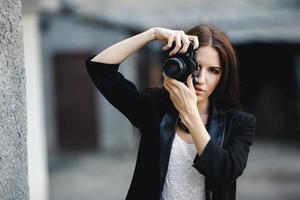 Beautiful female photographer posing with camera photo