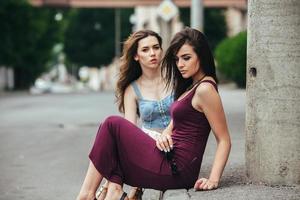 Two beautiful young girls posing in the city photo