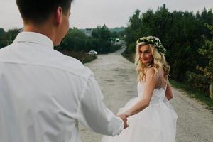 bride leads groom on the road photo