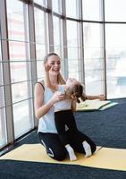 Mom and daughter together perform different exercises photo