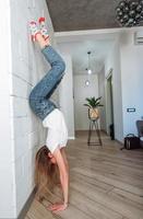 A woman is standing on his hands upside down photo