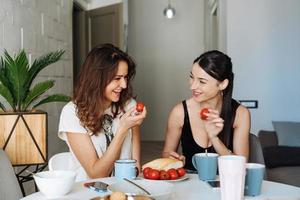 Two woman friends breakfast in the kitchen photo