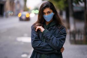 Young woman, person in protective medical sterile mask at empty street photo