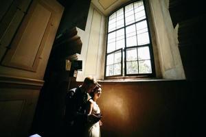 bride and groom on the background of a window. photo