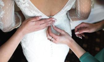 Bride putting on her dress photo