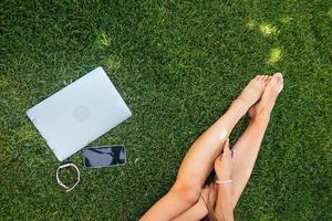 Young fit attractive woman lying on green lawn park. photo