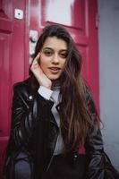 Young woman outdoor against a red door photo