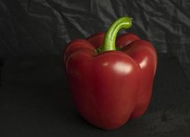 Fresh red sweet bulgarian pepper isolated on black background photo