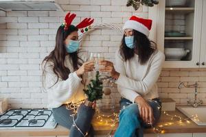 Two girls chatting, gossiping in the kitchen on new year's eve photo