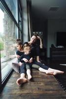 mamá y dos hijas juntas en la ventana foto