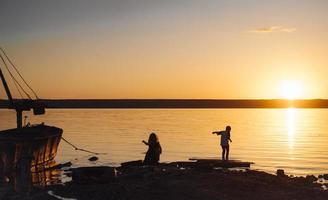 Two children walk along the beach, summer evening photo