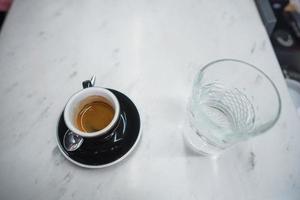 coffee mug and a glass of water on a table photo