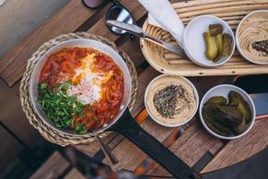 Shakshuka, Fried Eggs in Tomato Sauce on the Table photo