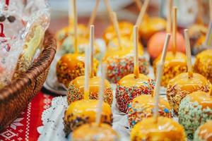 Apples in caramel and sprinkles. Street food. photo