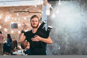 papá está sosteniendo a su pequeño hijo en sus brazos foto