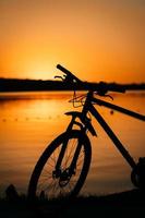 bicicleta en el fondo de una puesta de sol foto