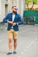 Stylish bearded man walks through the city photo