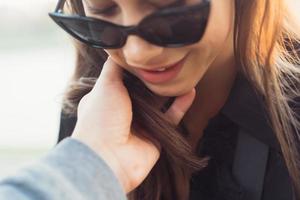 The guy gently holds the girl's hair photo