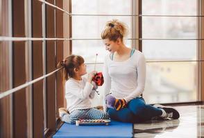 Mother and daughter makeing yoga in the gym photo