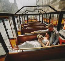 Bride and groom posing in a tour car photo