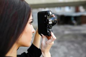 Beautiful female photographer posing with camera photo